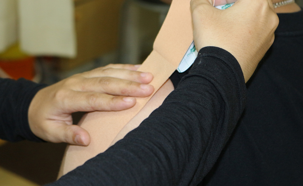 テーピングを肩に貼る